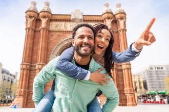 Man giving woman a piggy back ride in Europe while on a trip booked through a QVI holiday membership