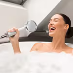 Lady in bathtub using HomePure Rayn shower head as a microphone