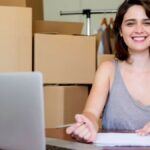 Girl smiling in front of boxes for her micro, small and medium-sized enterprise