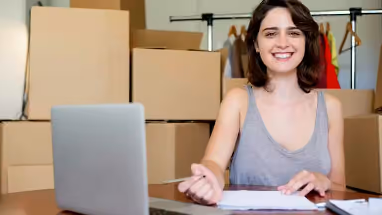 Girl smiling in front of boxes for her micro, small and medium-sized enterprise