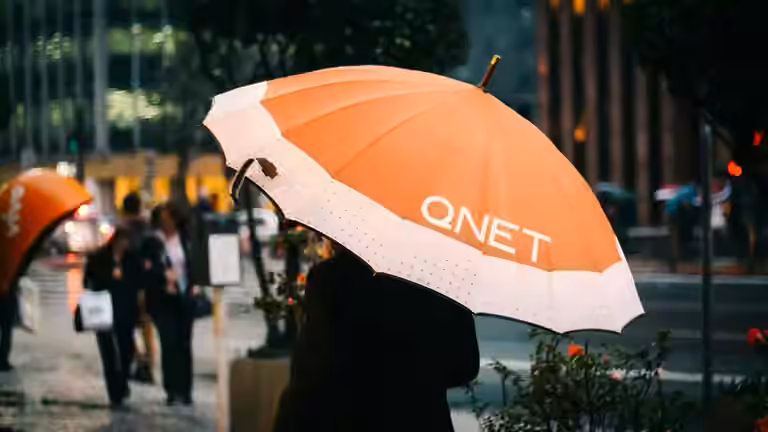 Monsoon Season Tips by QNET - girl with an orange umbrella